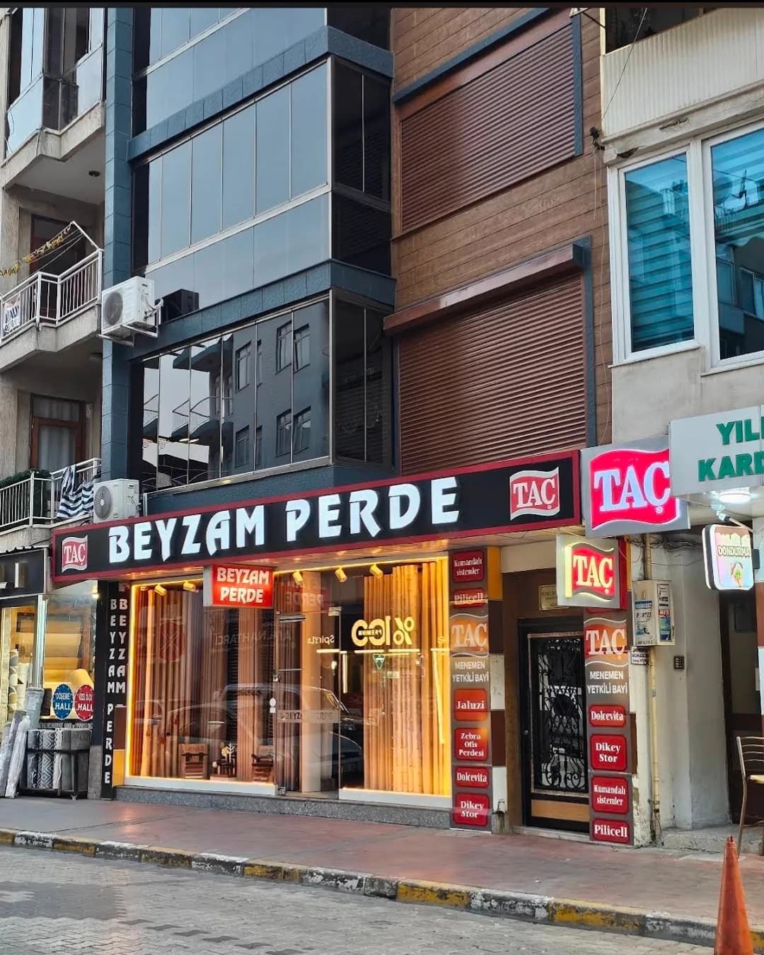 Beyzam Perde — Menemen Esatpaşa'daki mağazanın akşam görünümü, TAÇ yetkili bayi tabelasıyla